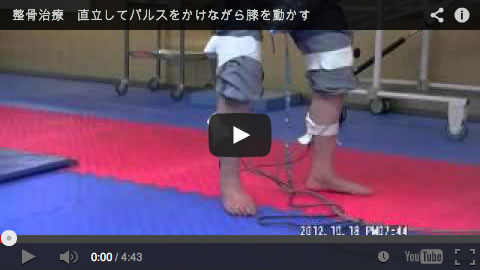 リハビリセンター大明　直立してパルスをかけながら暖かくして膝を動かす